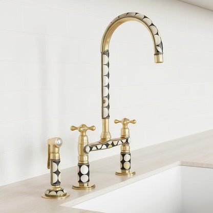 Angled view of handmade brass bridge kitchen faucet with dual handles