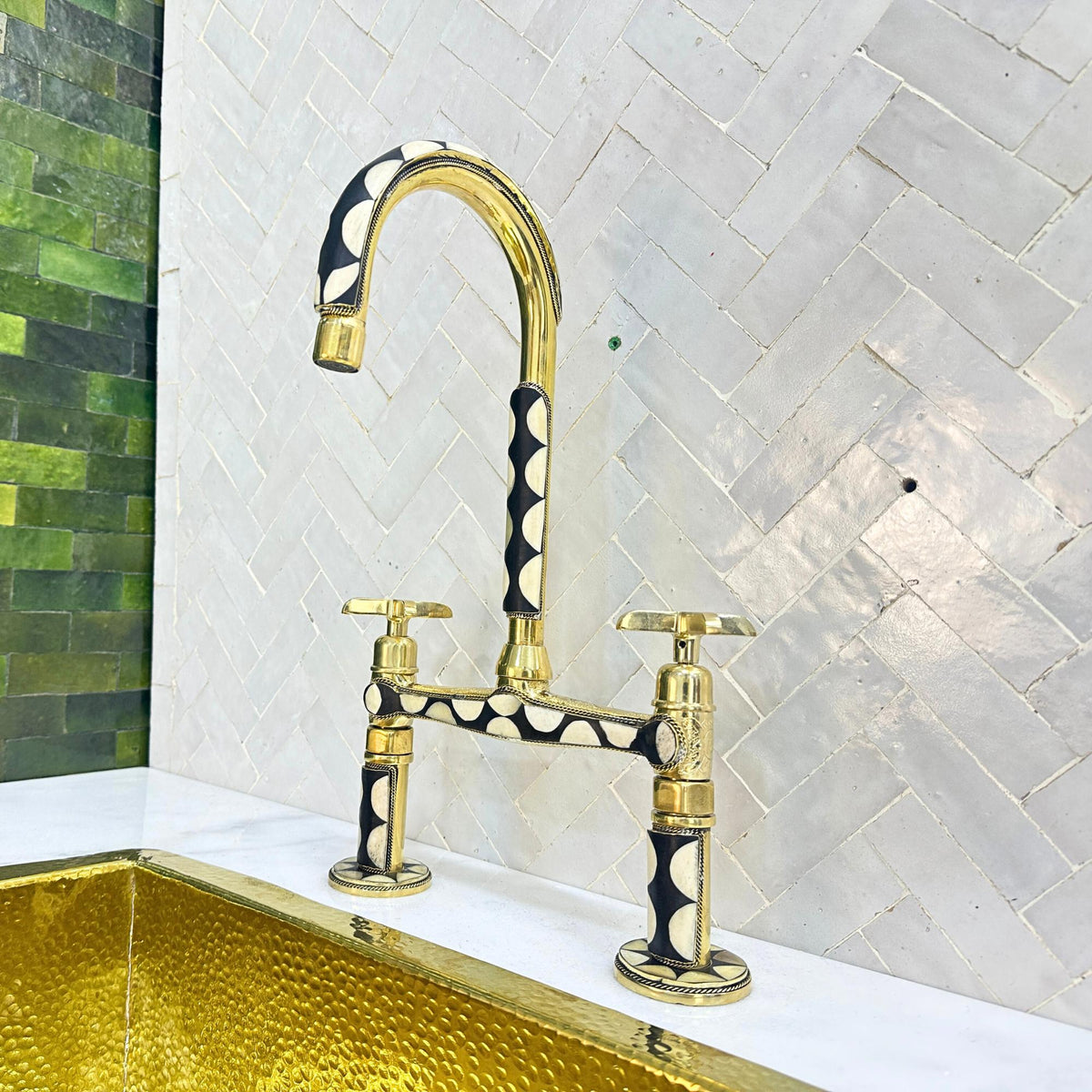 Close-up of decorative resin inlay on brass bridge kitchen faucet