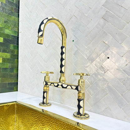 Close-up of decorative resin inlay on brass bridge kitchen faucet
