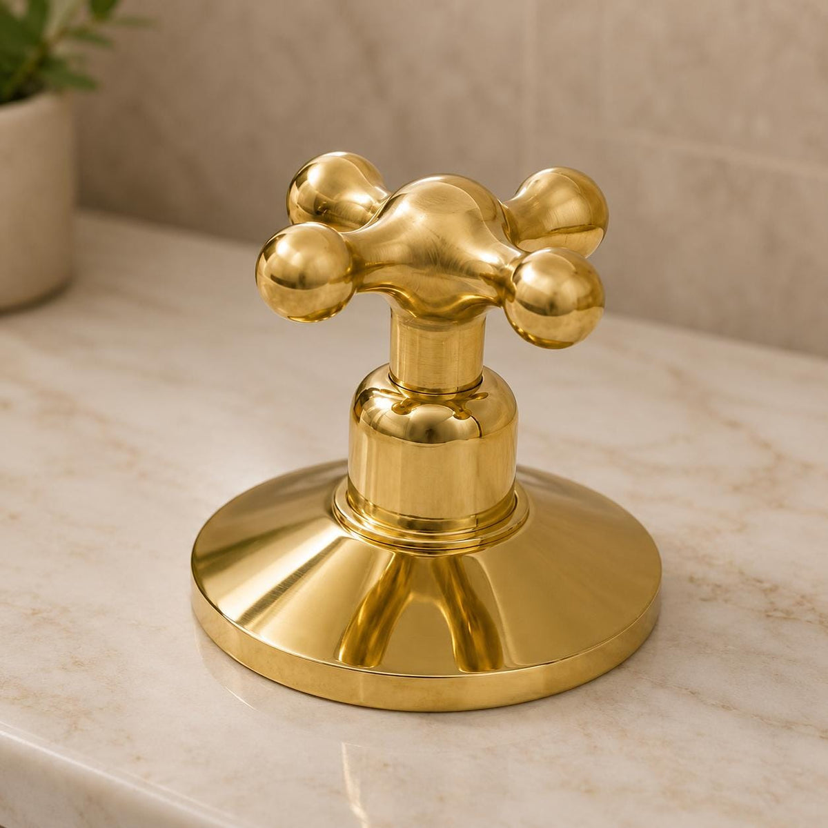 Close-up of dual handles on an unlacquered brass bathroom faucet