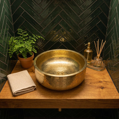 Close-up of hand engraved floral detailing on a brass vessel sink
