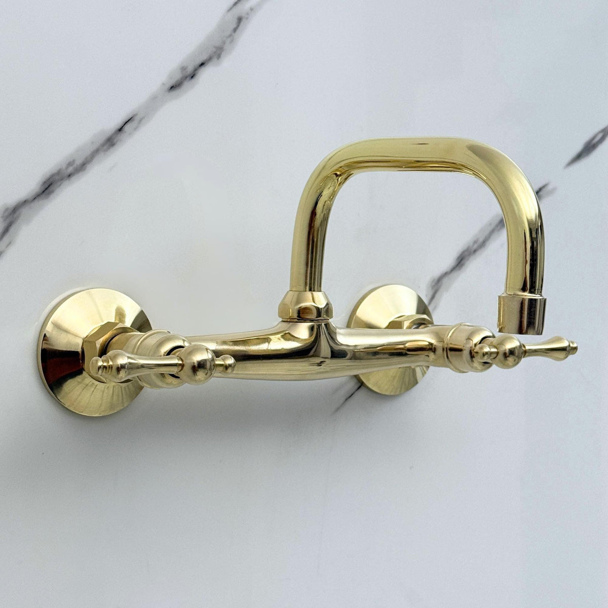 Close-up of premium lever handles on an unlacquered brass faucet