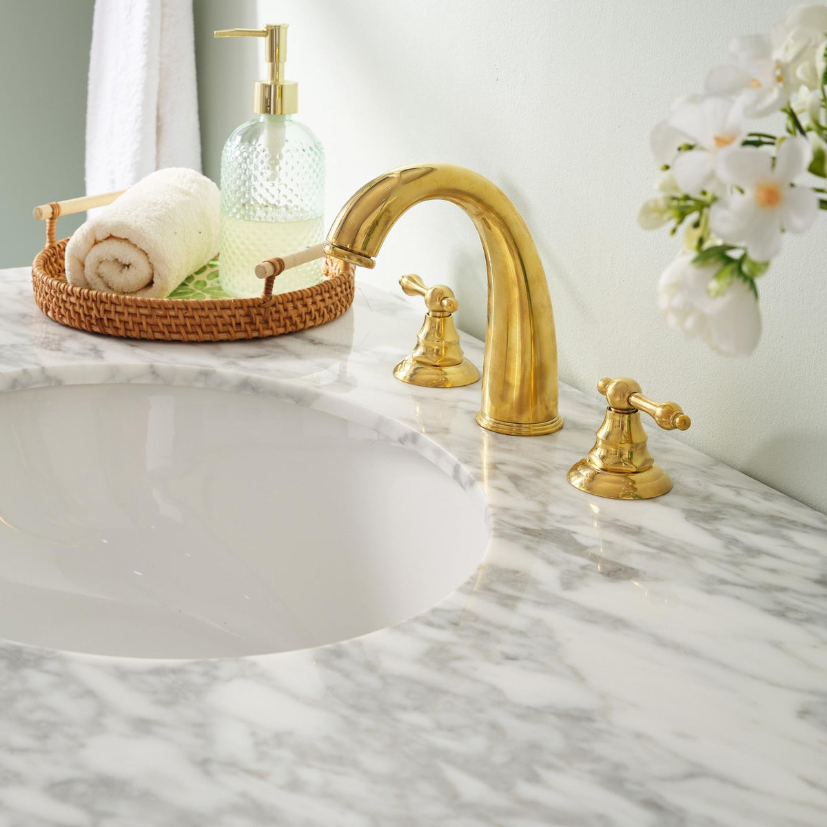 Close-up of the gooseneck spout on an unlacquered brass faucet