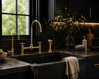 Dual cross handles on unlacquered brass bridge kitchen faucet