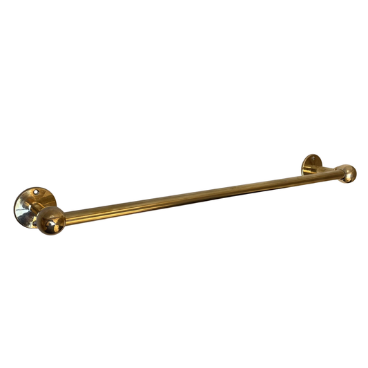 Handmade unlacquered brass towel rail mounted on a bathroom wall