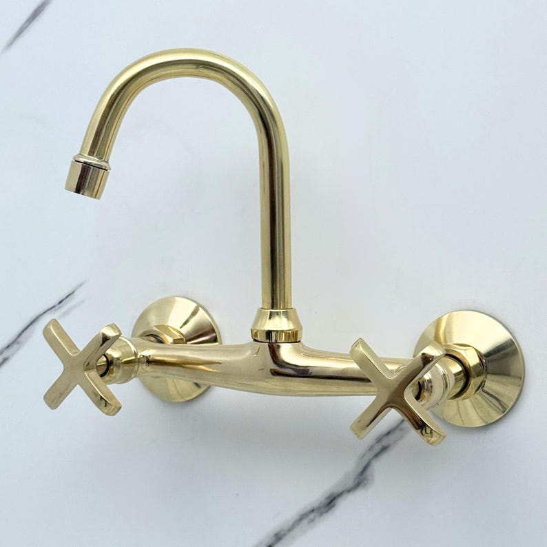 Luxury unlacquered brass bathroom faucet featuring traditional cross handles