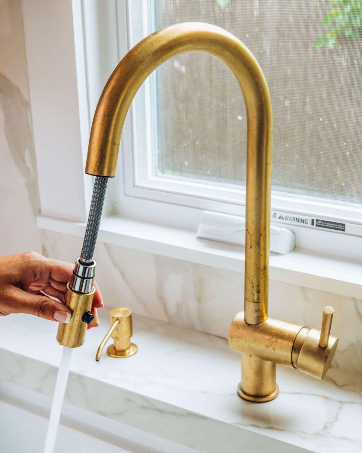 Pull-down sprayer head on industrial brass kitchen faucet