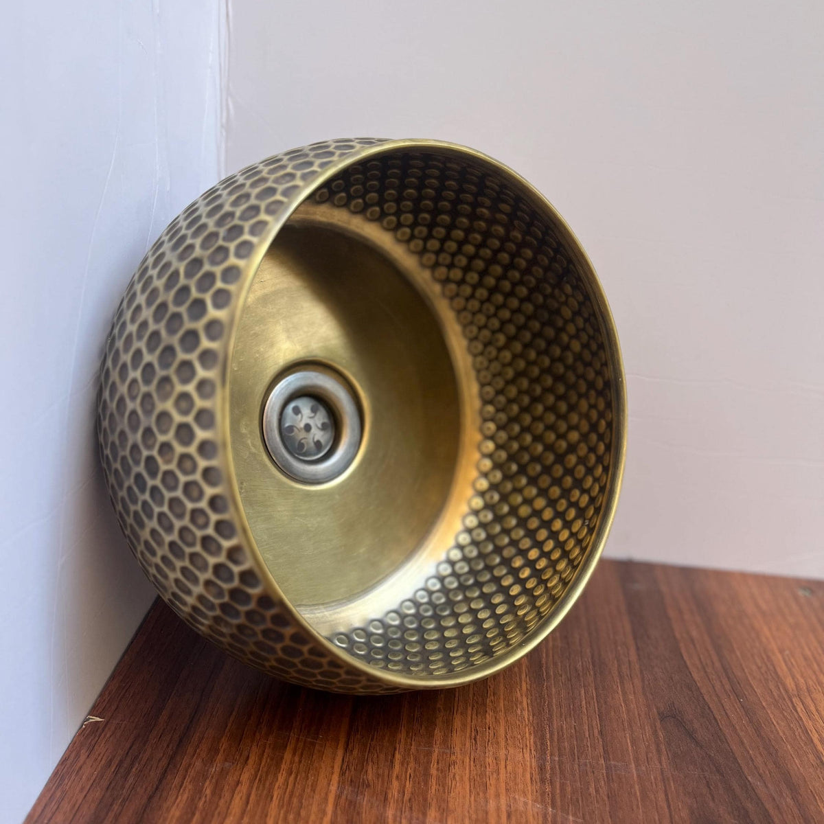 Round unlacquered brass vessel sink on a countertop vanity