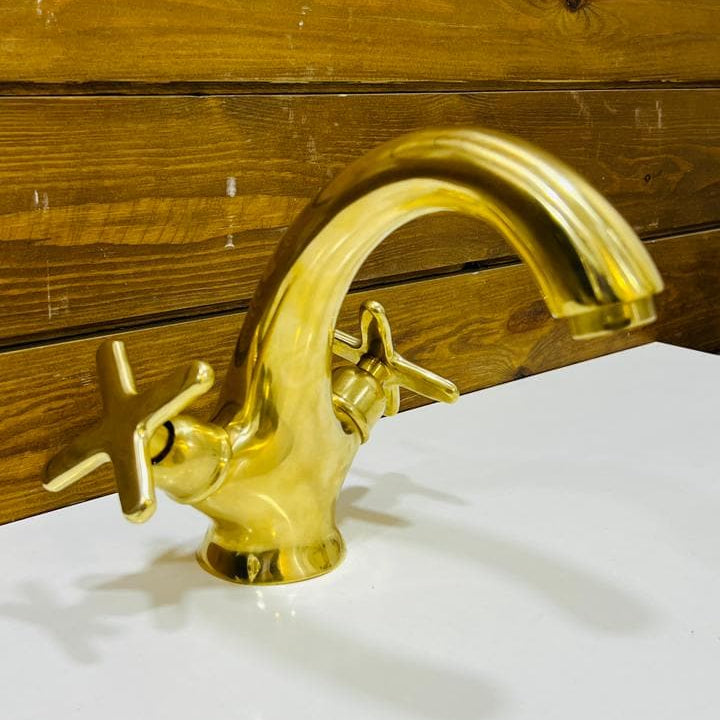 Side view of handcrafted unlacquered brass bathroom faucet with curved spout