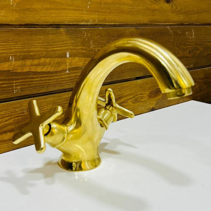 Side view of handcrafted unlacquered brass bathroom faucet with curved spout