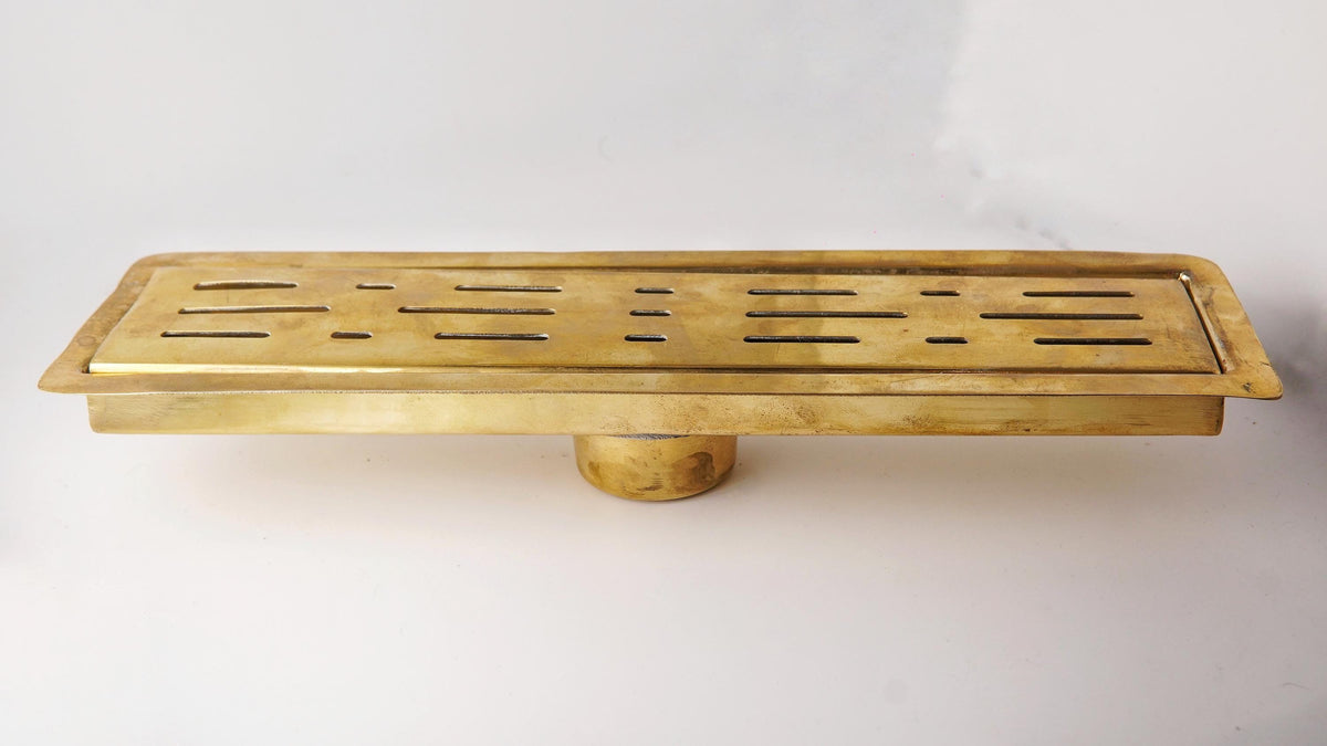 Solid brass linear floor drain with a living brass finish