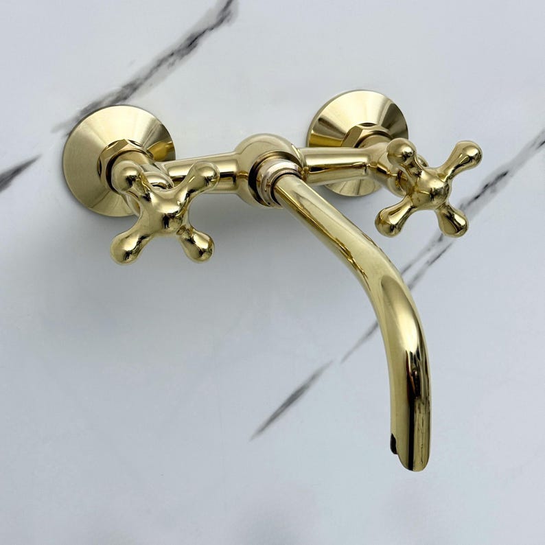 Unlacquered brass wall mount faucet installed in bathroom sink