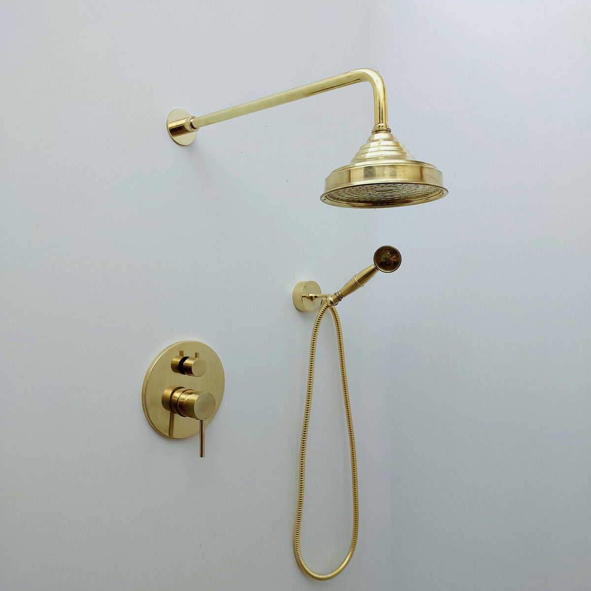 Unlacquered solid brass concealed shower with a handheld shower
