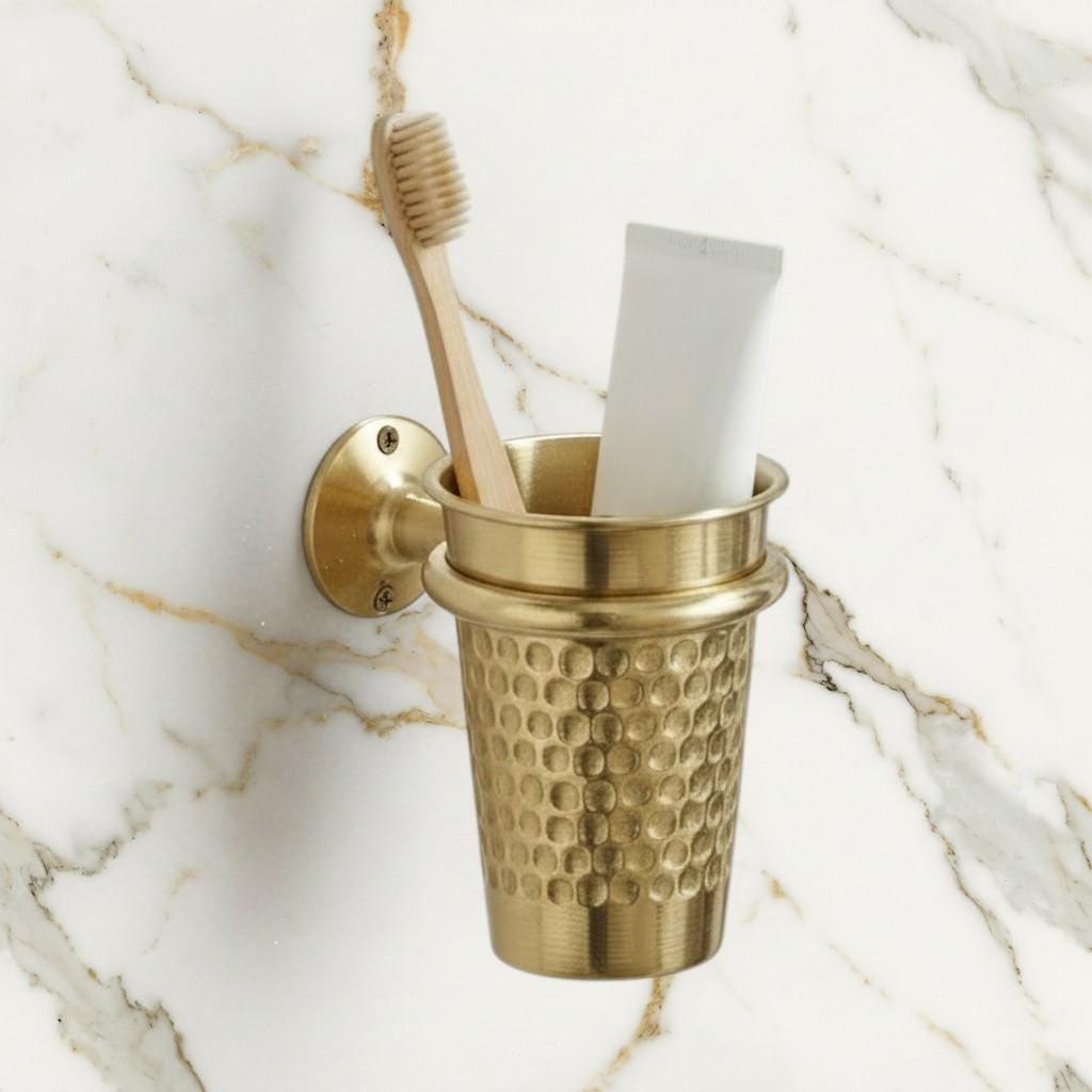 Wall mounted unlacquered brass toothbrush holder with a hammered finish