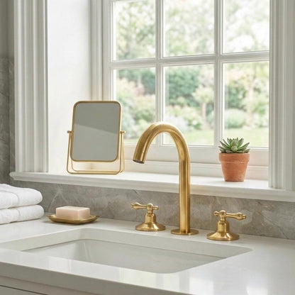 Close-up of high-arc gooseneck spout on brass widespread faucet