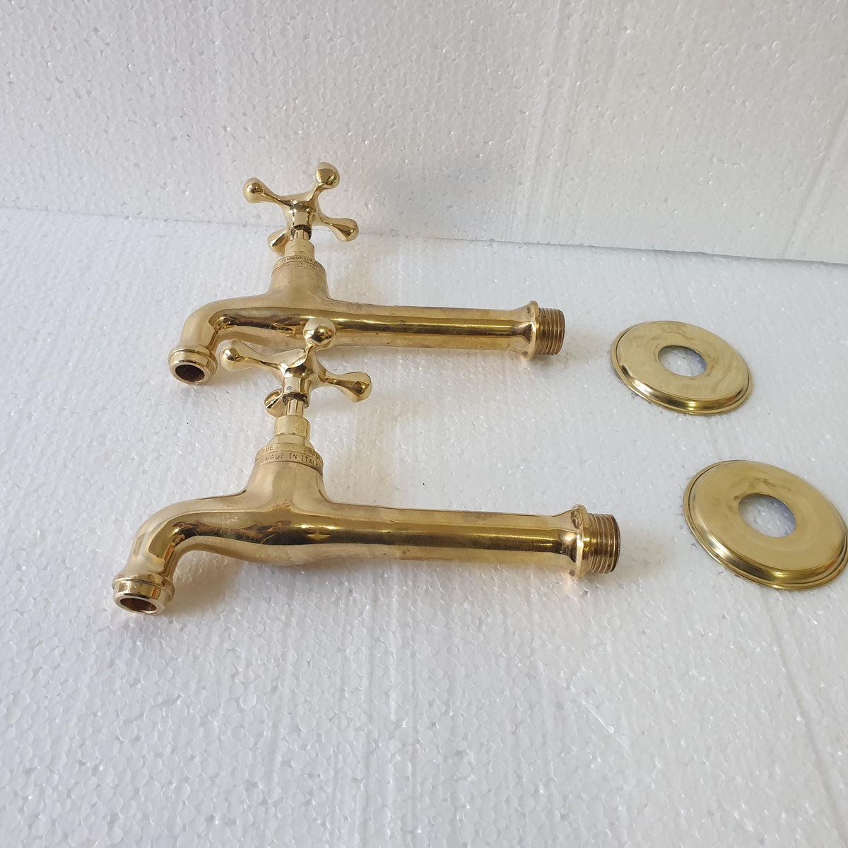 Angled view of unlacquered brass wall faucet with 14cm spout
