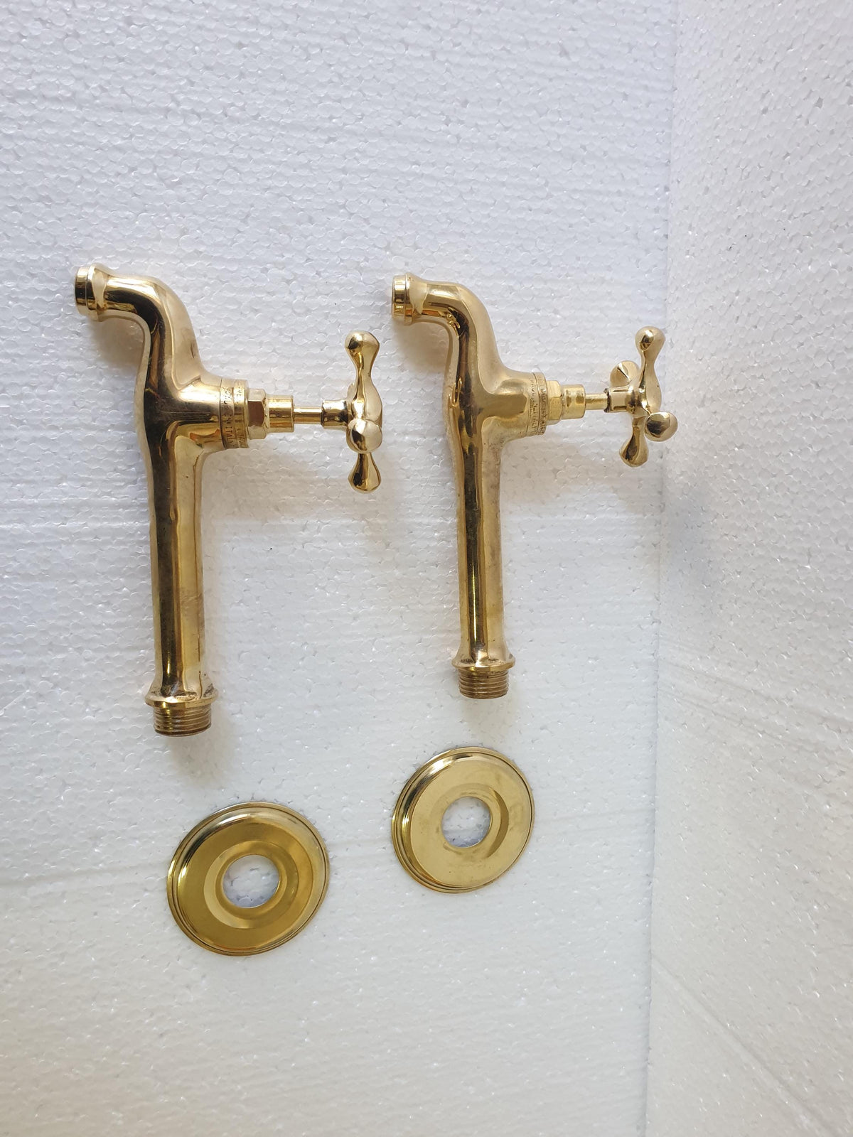 Angled view of unlacquered brass wall faucet with 14cm spout