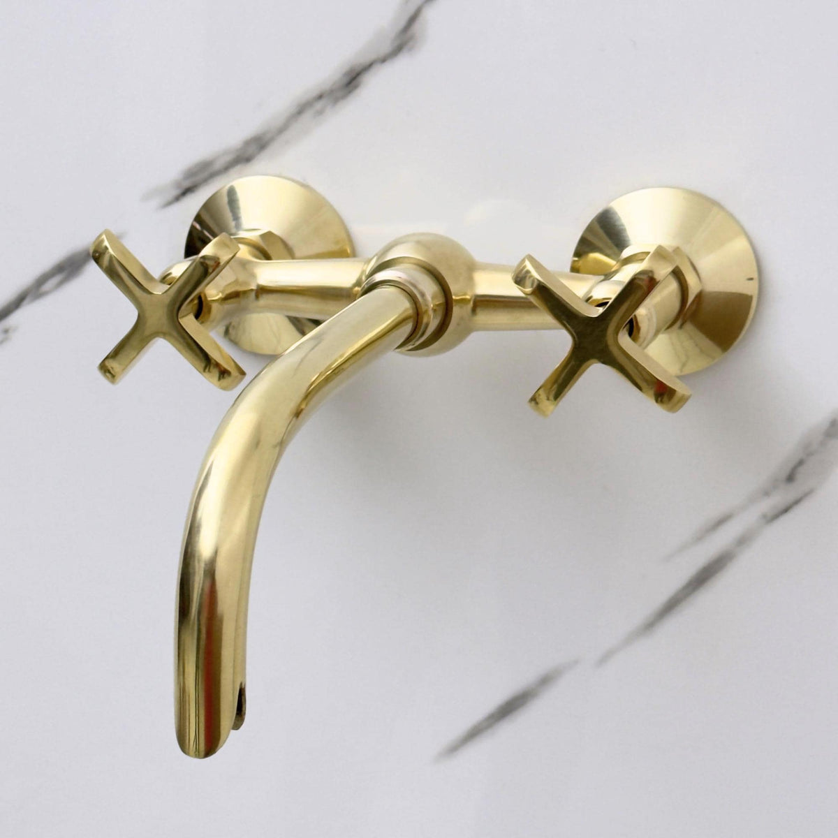 Unlacquered brass patina finish on wall mount bathroom faucet
